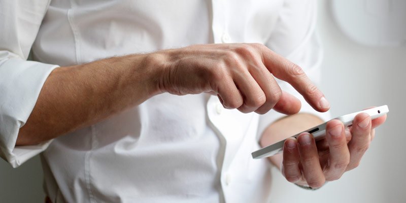 Hombre contactando por teléfono móvil con Salandelues